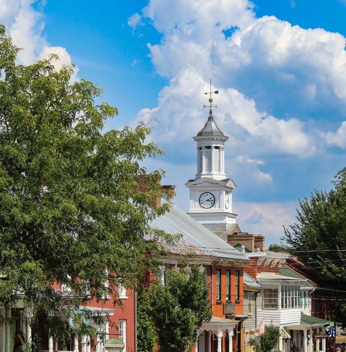 Quaint town scene with a classic clock tower and vibrant, clear blue sky.